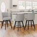 3 pcs gray upholstered swivel bar stool next to a counter with tufed design,back ,round seat and foot rest