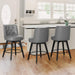 3 pcs dark grey upholstered swivel bar stool next to a counter with tufed design,back ,round seat and foot rest